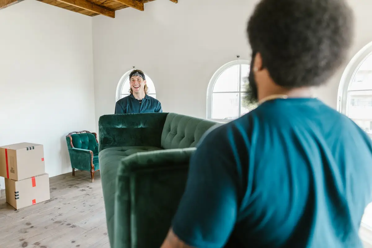 Movers carrying a couch past packed boxes